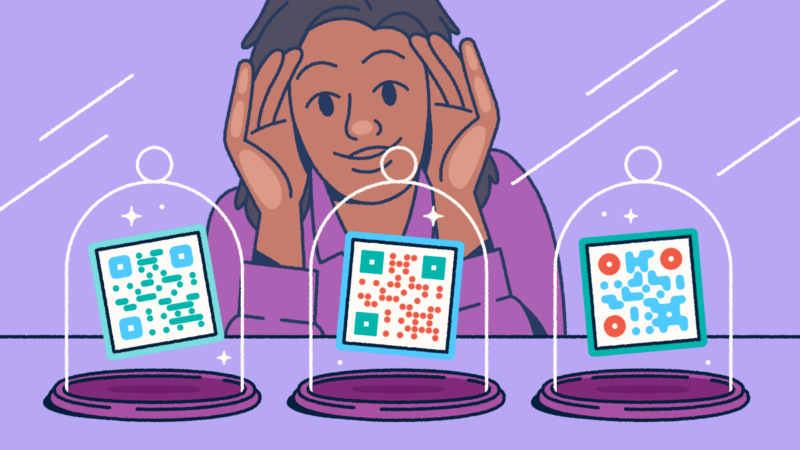 A person looking through a store-front window at three different QR codes on display in glass cloches.