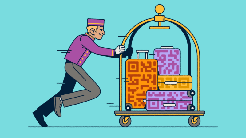 A bellhop pushing a luggage cart with several suitcases that have QR Code prints on them.