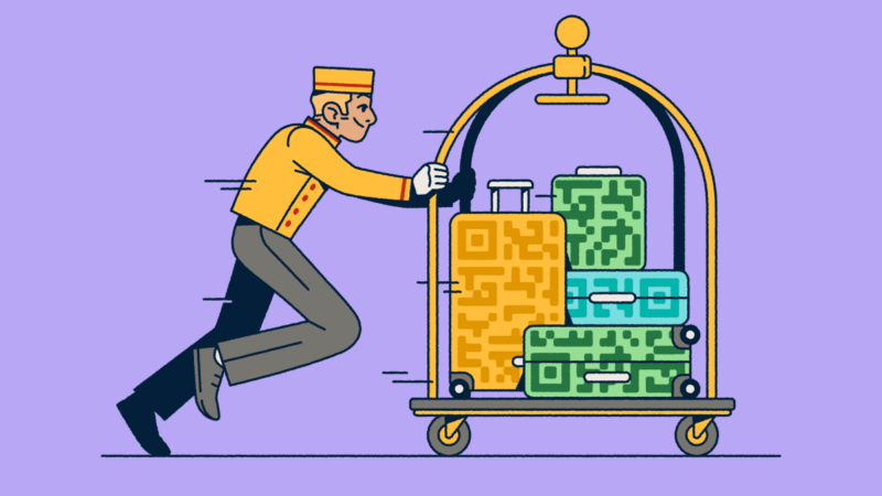 A bellhop pushing a luggage cart with several suitcases that have QR Code prints on them.