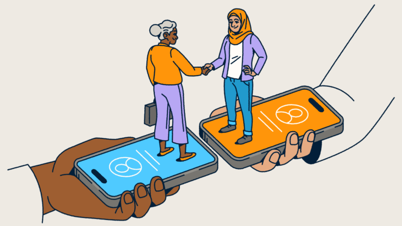 Two people standing on smartphones shaking hands.