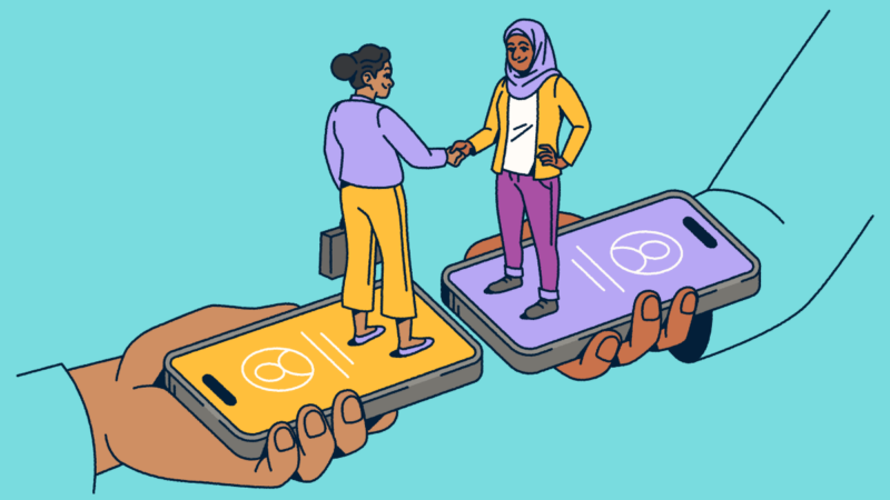 Two people standing on smartphones shaking hands.