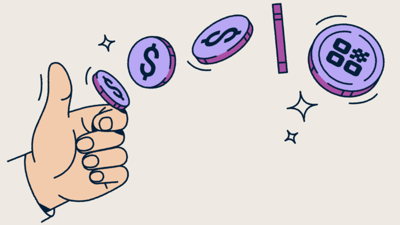 A hand flipping a coin with a QR Code on it.