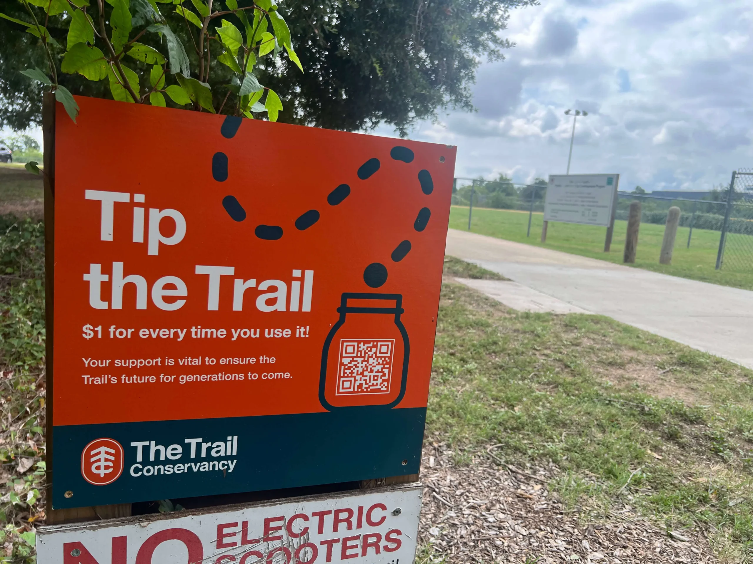 A park sign with a QR Code promoting The Trail Conservancy’s “Tip the Trail” donation program.