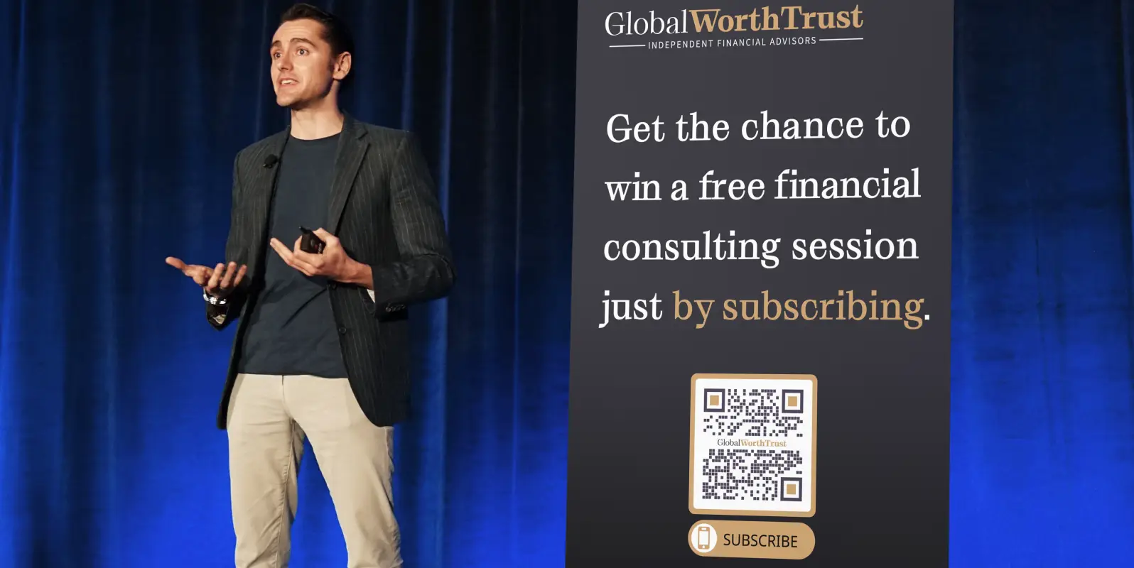 Man presenting and standing next to a big banner ad for a finance company with a QR code on it.