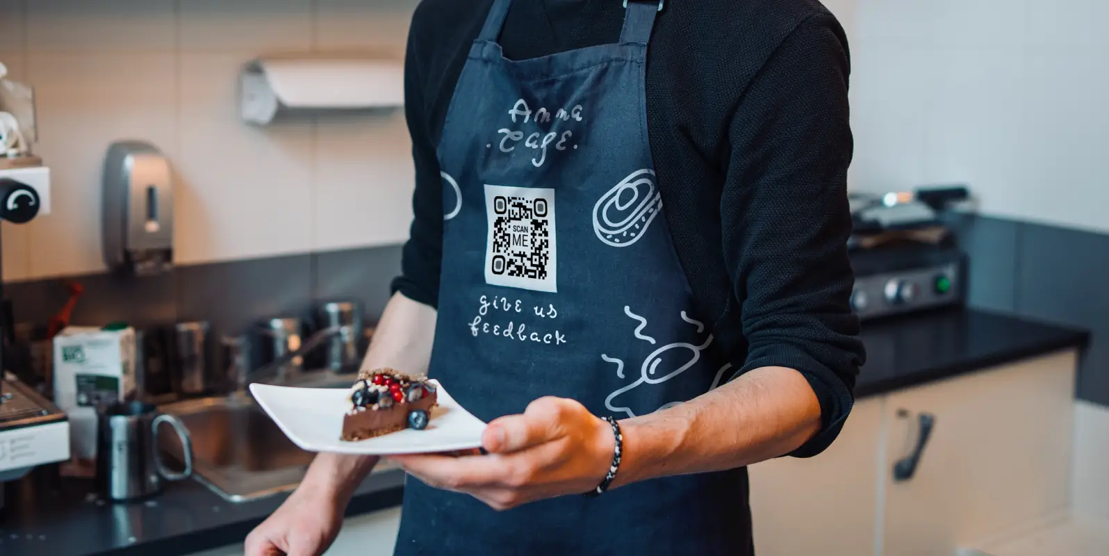 Close-up of a person wearing an apron with a QR Code on it.