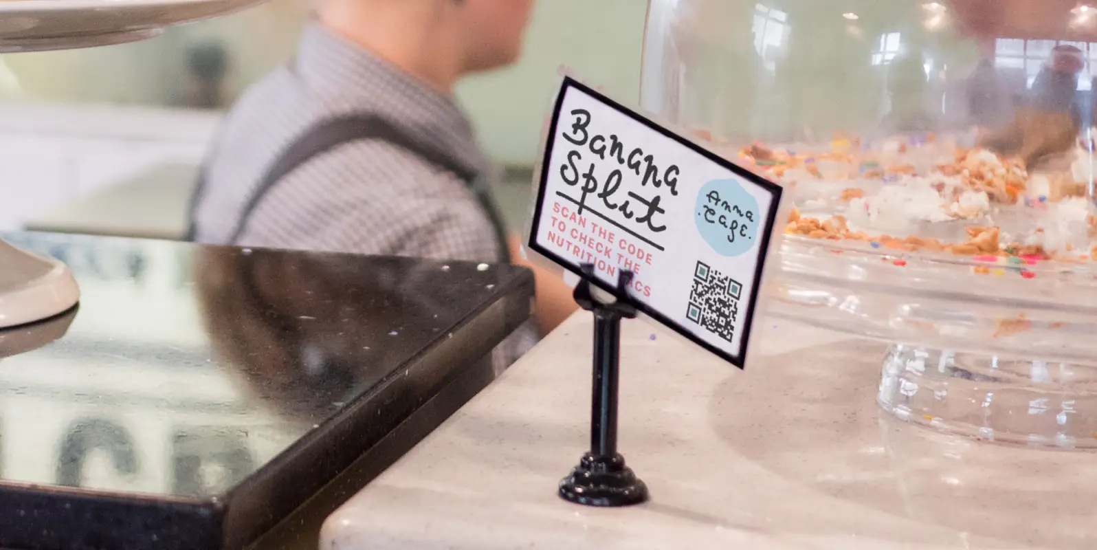 A cafe tabletop display card with a qr code on it.