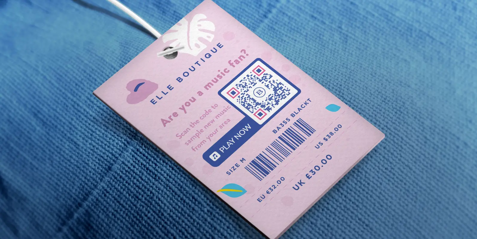 Close up of a piece of blue clothing with a pink hang tag with a music qr code on it.