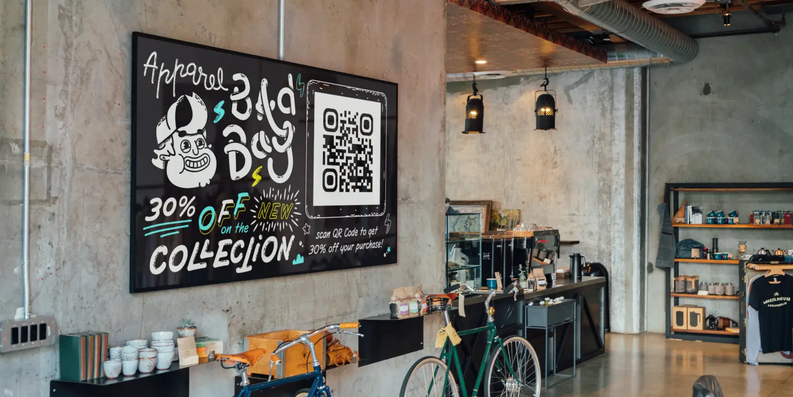 Retailer's black advertisement board hanging on a wall with white writing prompting to scan the QR Code for a discount.
